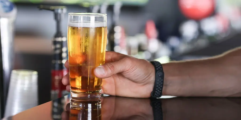 Man's,Hand,Holds,Glass,Of,Beer,On,Bar.,All,Inclusive