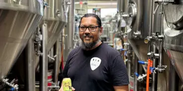 Man in a brewery holding a beer