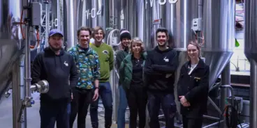 Group of people in front of Science Made Beerable brewing equipment
