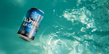 Can of Alpine Lager by Bright Brewery floating in water