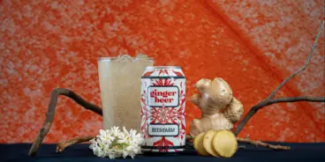 Can of Beerfarm's Ginger beer between a glass and a knob of ginger